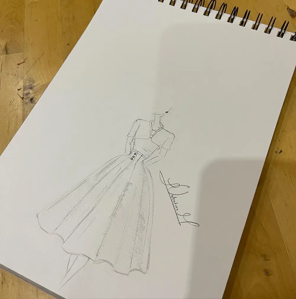 Boceto a lápiz de un vestido con falda amplia, cinturón y botones